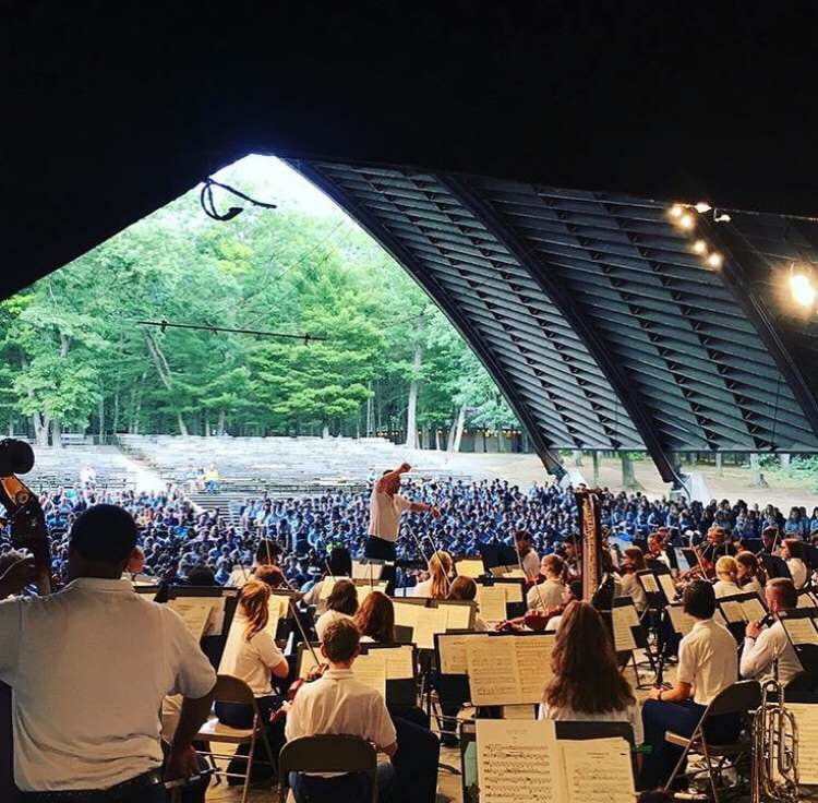 Musicians performing for a crowd in an outdoor amphitheater