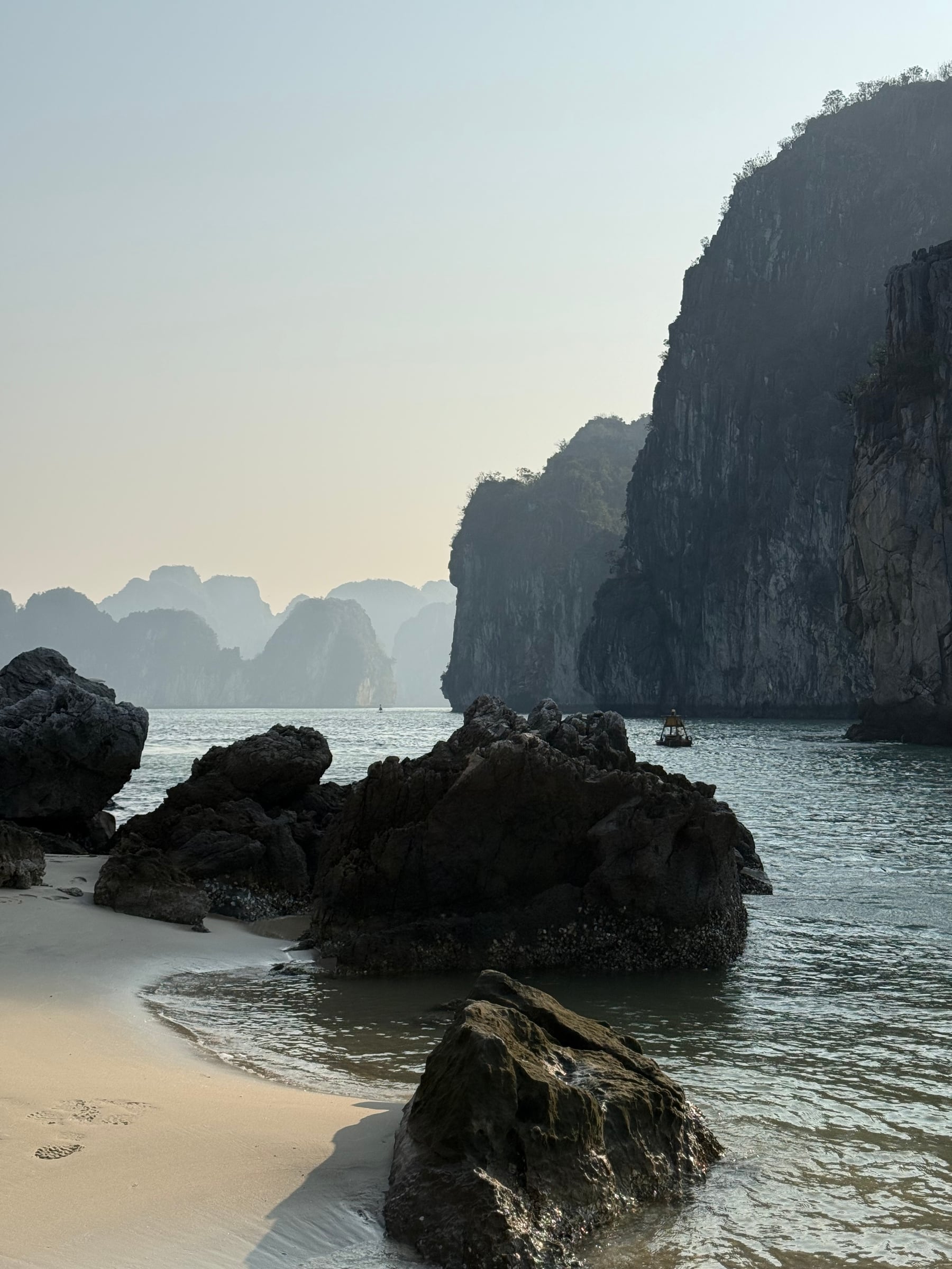 Rocky shoreline framed by limestone cliffs and distant islands