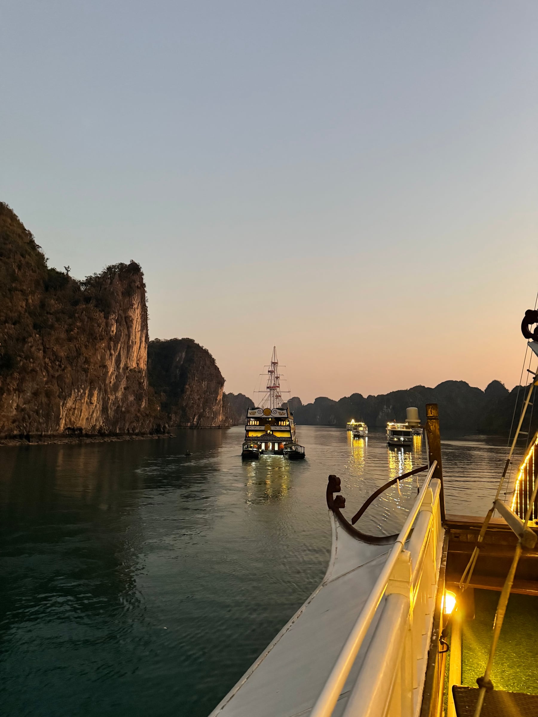Passenger boats glowing at sunset among limestone cliffs